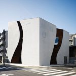 Sunwell Muse Kitasando: Dos muros curvos de hormigón que definen la forma de un complejo de modas